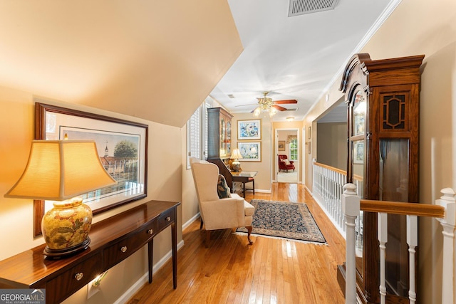 interior space featuring ceiling fan, light hardwood / wood-style flooring, and crown molding