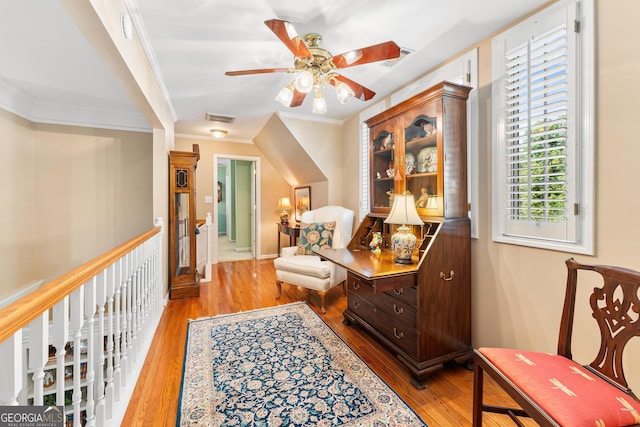 sitting room featuring ceiling fan, light wood-type flooring, and crown molding