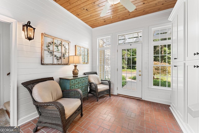 sitting room featuring ceiling fan, wood ceiling, wood walls, and crown molding