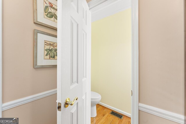 bathroom featuring hardwood / wood-style flooring and toilet