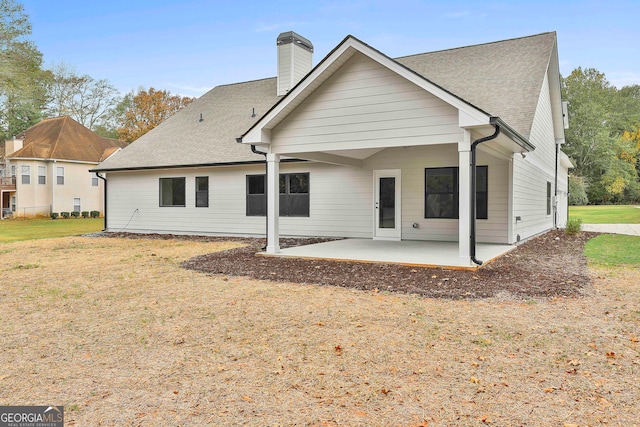 rear view of house featuring a yard and a patio area