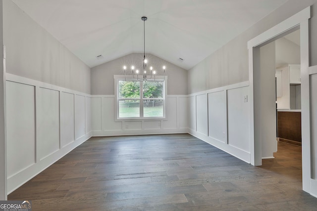 unfurnished dining area featuring lofted ceiling, dark wood-type flooring, and a notable chandelier