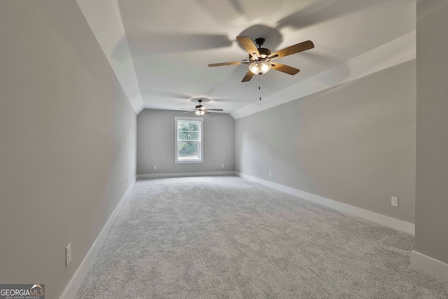 spare room featuring ceiling fan, light colored carpet, and vaulted ceiling