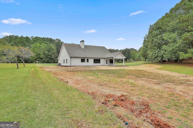 rear view of property featuring a lawn and a patio