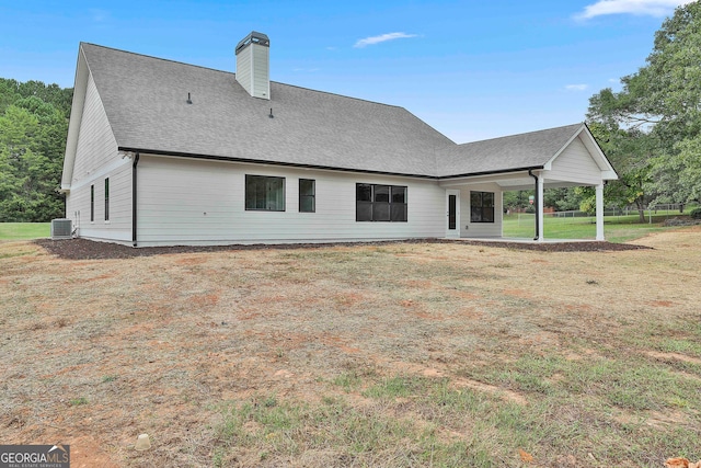 rear view of house featuring central AC unit, a patio area, and a lawn