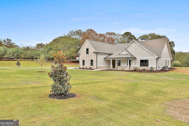 view of front of home with central AC unit, a front lawn, and covered porch