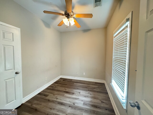 empty room with ceiling fan and dark hardwood / wood-style flooring