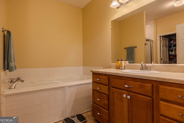 bathroom featuring shower with separate bathtub, tile patterned floors, and vanity