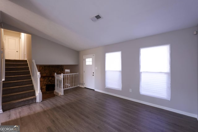 unfurnished living room with dark wood-type flooring and vaulted ceiling