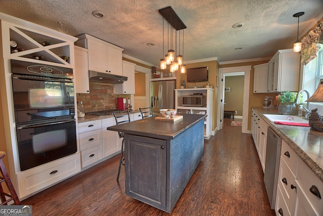 kitchen with stainless steel appliances, white cabinetry, and a kitchen island