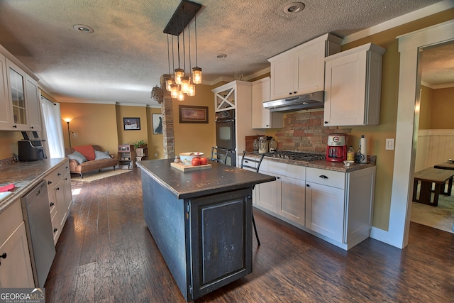 kitchen featuring dark hardwood / wood-style floors, white cabinetry, hanging light fixtures, a kitchen island, and appliances with stainless steel finishes