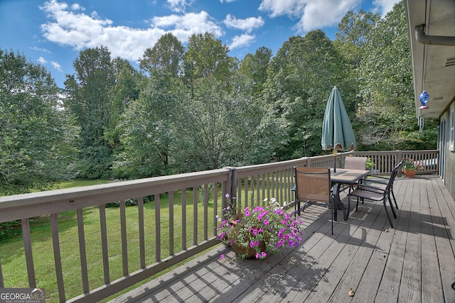 wooden deck featuring a lawn