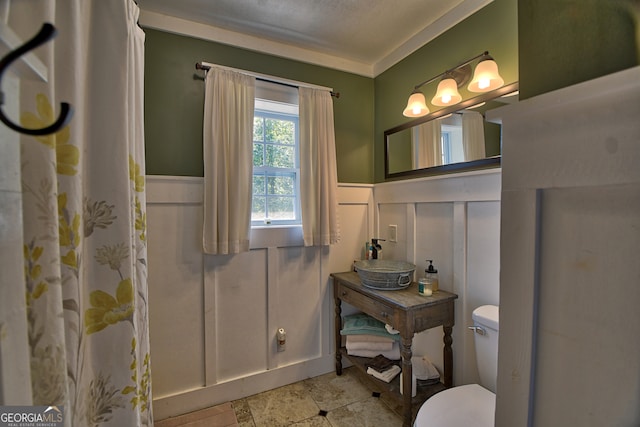 bathroom with crown molding and toilet