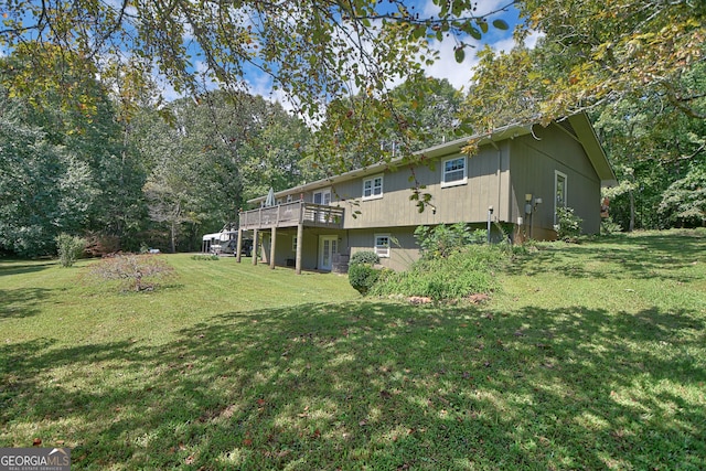 rear view of house with a wooden deck and a yard