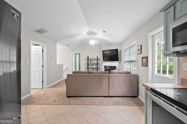 tiled living room featuring lofted ceiling and ceiling fan