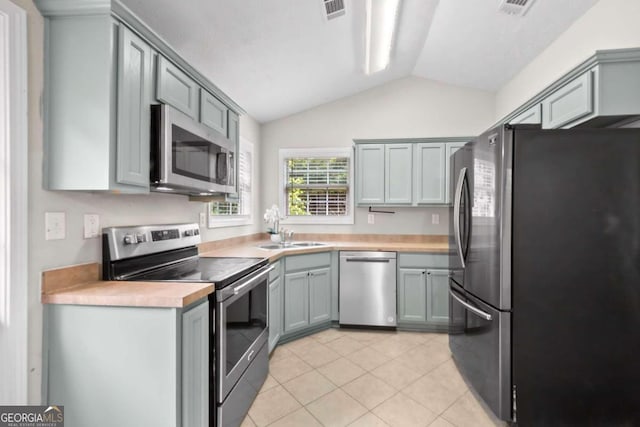 kitchen featuring vaulted ceiling, sink, and stainless steel appliances