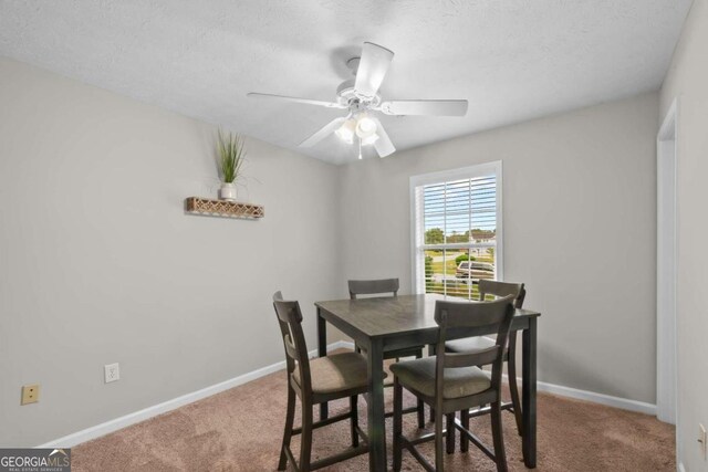 dining room featuring ceiling fan, a textured ceiling, and carpet