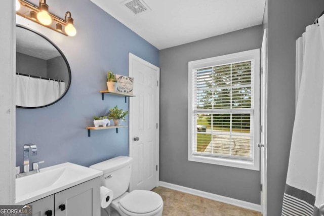 bathroom with tile patterned flooring, vanity, and toilet