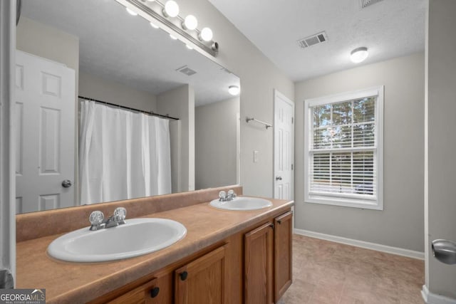 bathroom featuring a textured ceiling and vanity