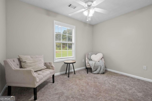 living area featuring light carpet and ceiling fan