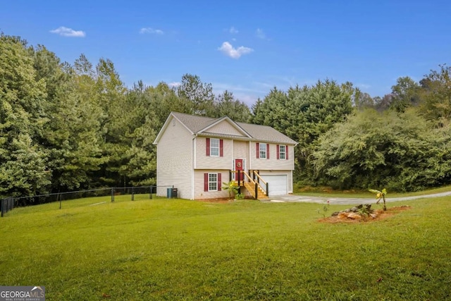 bi-level home featuring a front lawn, central air condition unit, and a garage