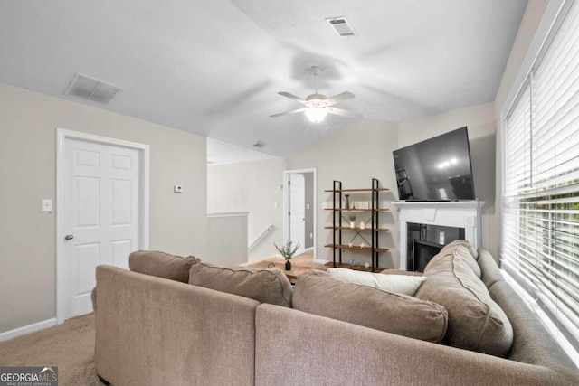 living room with ceiling fan, lofted ceiling, and light carpet