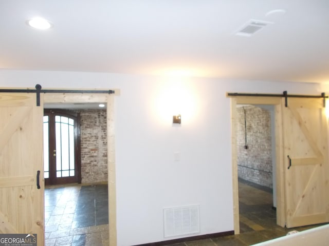 140 Walker St SW Unit A, Atlanta, GA 30313 - spare room featuring a barn door and stone tile flooring