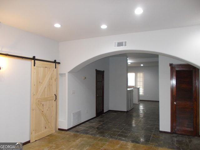 140 Walker St SW Unit A, Atlanta, GA 30313 - spare room with stone tile floors, baseboards, a barn door, recessed lighting, and arched walkways