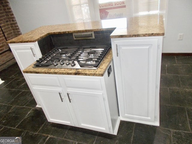 140 Walker St SW Unit A, Atlanta, GA 30313 - kitchen with light stone counters, white cabinetry, stainless steel gas cooktop, and baseboards