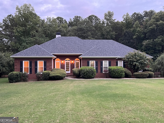 single story home featuring a front lawn