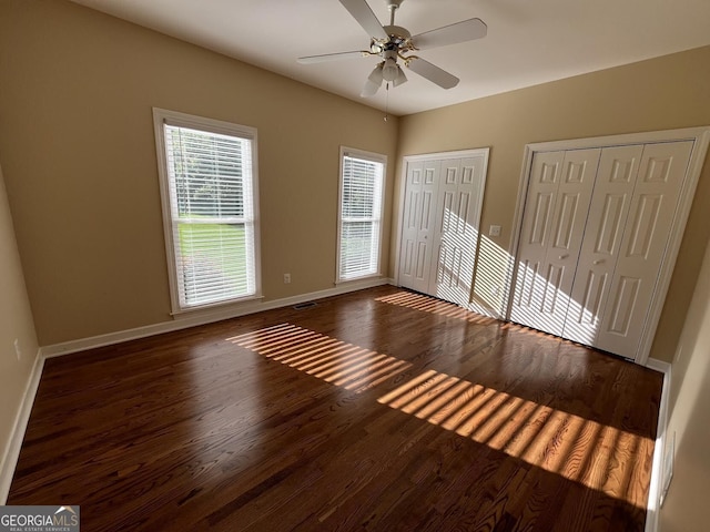 202 Maplewood Cir, Griffin, GA 30224 - unfurnished bedroom with two closets, wood finished floors, multiple windows, and baseboards