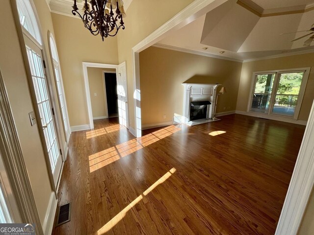202 Maplewood Cir, Griffin, GA 30224 - unfurnished living room with crown molding, wood finished floors, a fireplace with flush hearth, a chandelier, and baseboards