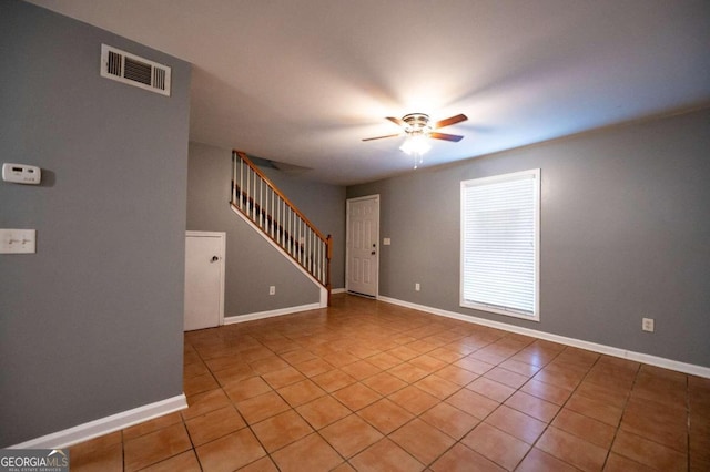 tiled spare room featuring ceiling fan