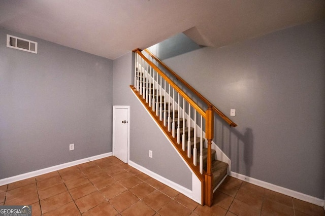 stairway with tile patterned floors