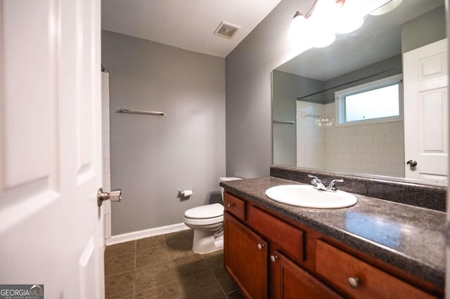 bathroom featuring tiled shower, vanity, toilet, and tile patterned floors