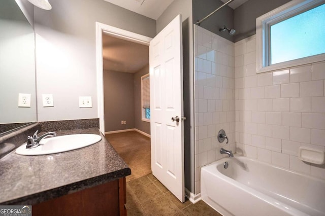 bathroom featuring tile patterned floors, tiled shower / bath combo, and vanity