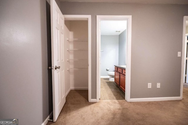 corridor featuring light colored carpet