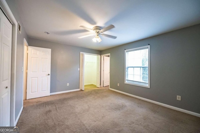 unfurnished bedroom featuring ceiling fan, a closet, and light carpet