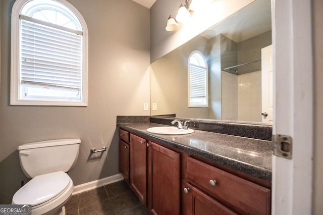 bathroom featuring tiled shower, vanity, toilet, and tile patterned floors