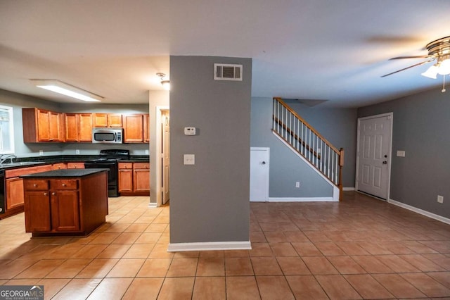 kitchen with black appliances, ceiling fan, light tile patterned flooring, and a kitchen island