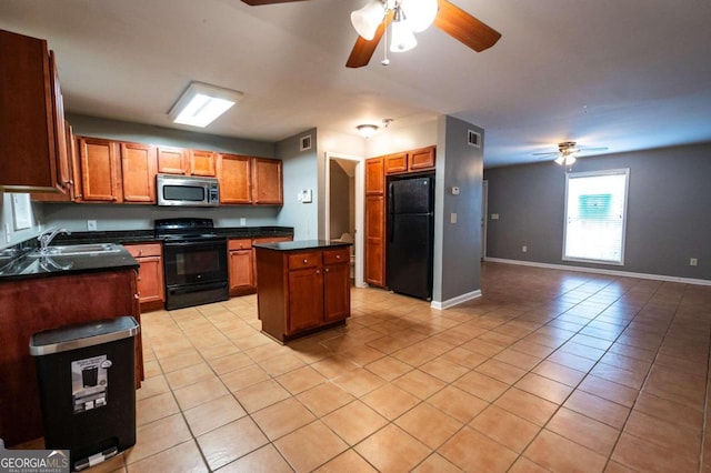 kitchen featuring ceiling fan, light tile patterned flooring, sink, black appliances, and a center island