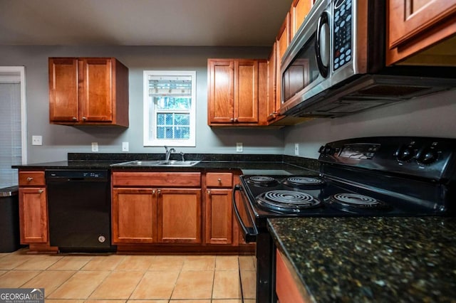 kitchen featuring dark stone counters, black appliances, light tile patterned flooring, and sink