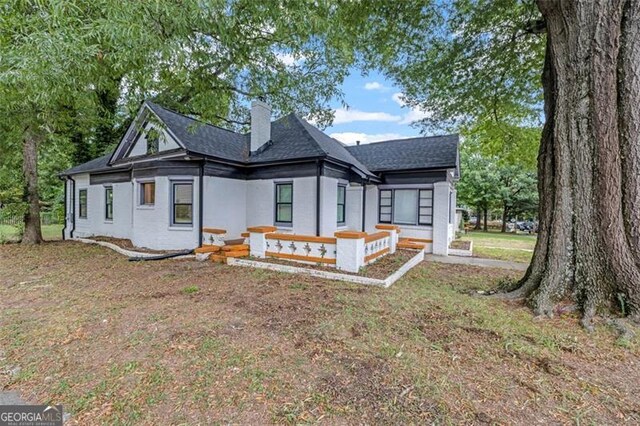 rear view of property featuring a lawn