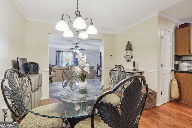 dining space with ceiling fan with notable chandelier, light hardwood / wood-style flooring, and ornamental molding