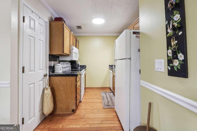 kitchen featuring light wood-type flooring, crown molding, white appliances, and tasteful backsplash