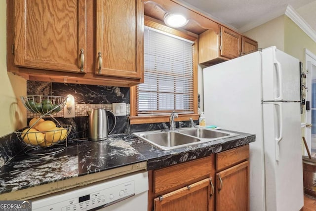 kitchen with backsplash, white appliances, crown molding, and sink