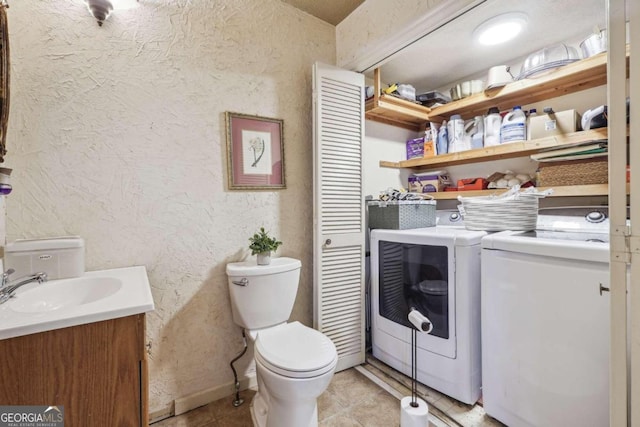 washroom featuring sink, light tile patterned floors, and washing machine and dryer