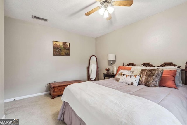 carpeted bedroom featuring ceiling fan and a textured ceiling