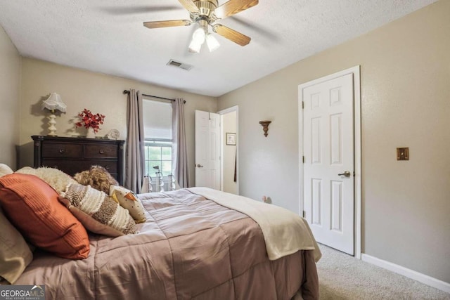 carpeted bedroom featuring a textured ceiling and ceiling fan