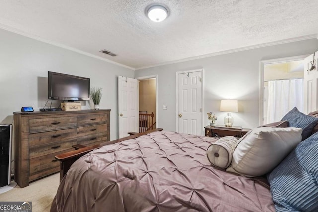 bedroom with a textured ceiling, ornamental molding, and light colored carpet